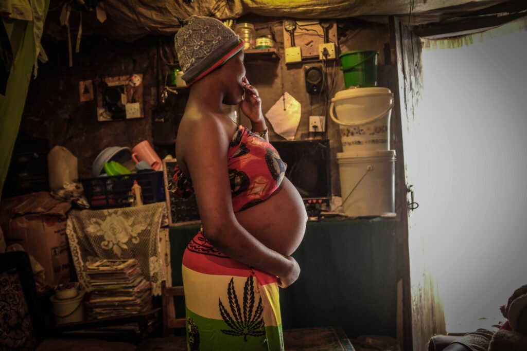 NAIROBI, KENYA - 2020/06/25: 18 year old Viela Akinyi is seen holding her baby bump inside her home in Kibera Slums. Some research indicates that up to a third of more of girls aged between 15-22 living in Nairobis main slums experience an unwanted pregnancy. (Photo by Donwilson Odhiambo/SOPA Images/LightRocket via Getty Images)